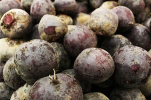 A pile of fresh, organic beetroots showcasing their natural texture and earthy colors.